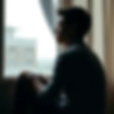 Person Reflecting on Loss Individual sitting alone in a contemplative pose, looking out a window, symbolizing the impact of loss and reflection on life choices.